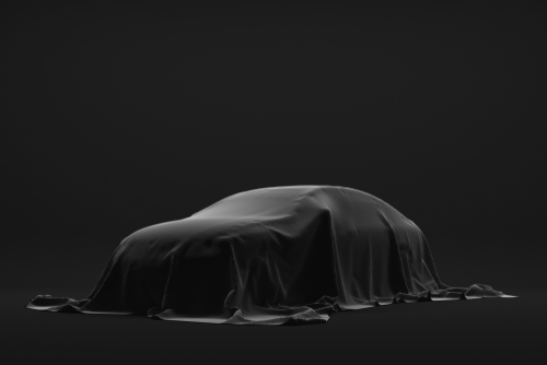 The,Automobile,Is,Covered,Dark,Cloth,On,A,Black,Background.